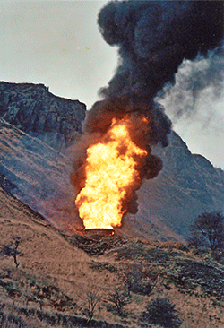 Grass burns on the hillside due to the intense heat radiated from the flames shooting up ventilation shafts, fuelled by 1 million litres of petrol in Summit Tunnel below. RAY BANYARD.