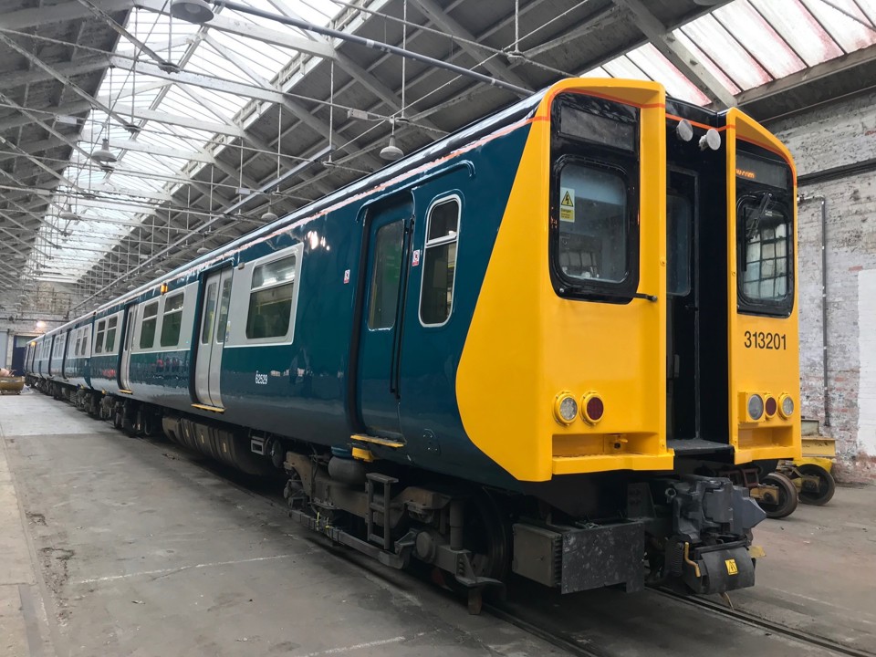 Repainted 313201 stands inside Wolverton Works, displaying its newly applied British Rail blue and grey. GTR. 