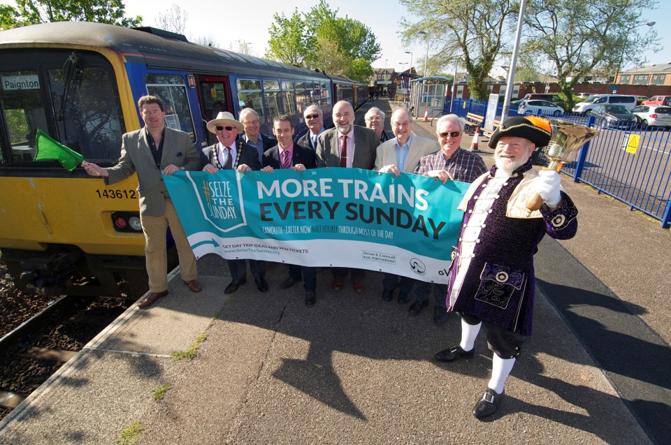 Councillor Andrew Leadbetter (left) waves off the new Sunday service with Deputy Mayor for Exmouth Brian Cole, GWR Driver Competence Manager Paul Samways, Driver Competence Manager and chairman of Avocet Line Rail Users’ Group Mike Reddaway, ALRUG Committee members, and Exmouth Town Crier Roger Bourgein. GWR.