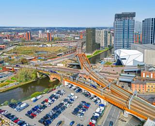 Northern 331023 and 331012 approach Water Street Junction (Manchester) with the electric 1156 Blackpool North-Manchester Airport, passing a car park off Water Street