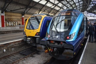 Northern and TPE train sitting at Manchester Railway Station